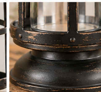 Close-up of the Curtis Island lantern’s round pedestal base and distressed black finish