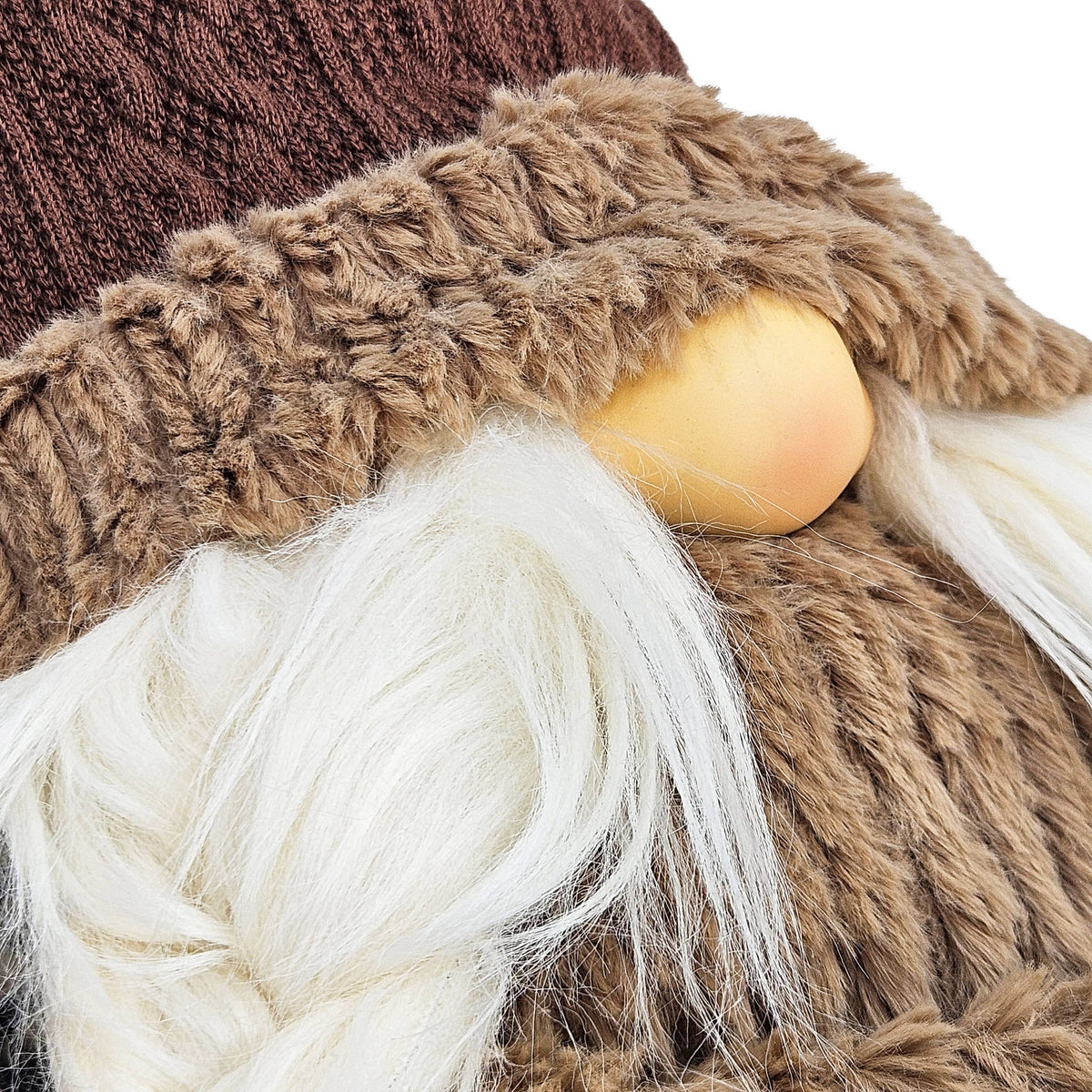 Close-up of the harvest gnome’s round nose, braided white beard, and shaggy tan hat trim