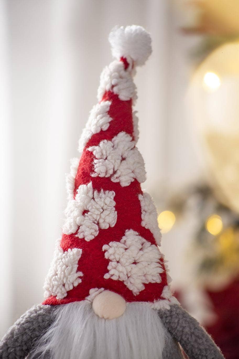 Close-up of the gnome’s red hat with raised white snowflake appliqués, white pom-pom, cream nose, and fluffy white beard.