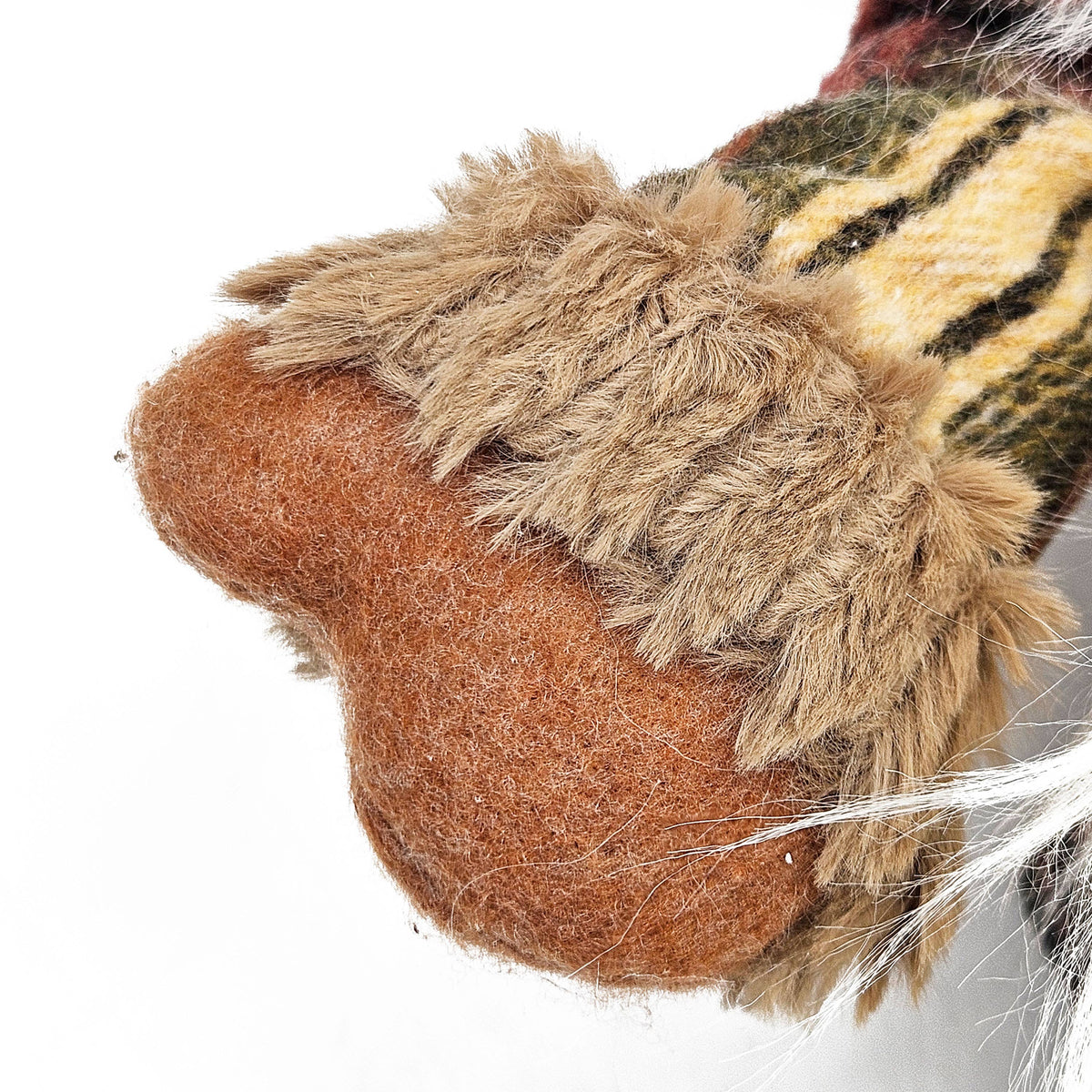 Close-up of the harvest gnome’s brown mitten with shaggy tan cuff and plaid sleeve