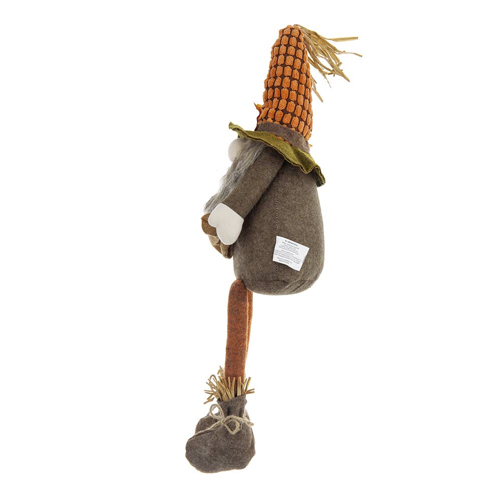 Side view of the Harvest Scarecrow Gnome Plush with a corn-textured hat, white mitten, and dangling orange legs