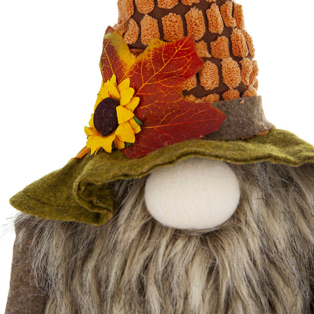 Close-up of the scarecrow gnome’s corn-textured hat with a sunflower, autumn leaves, green brim, and shaggy gray beard