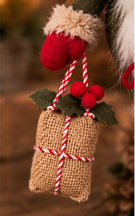 Close-up of the Christmas gnome’s burlap gift with red-and-white cord, holly leaves, and red berries