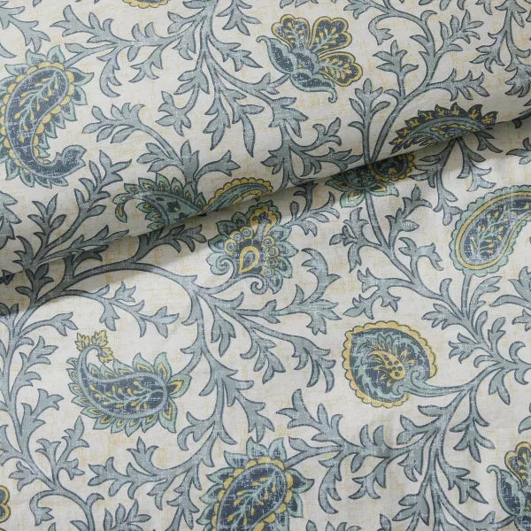 Close-up of the Madison Park Dawn bedding’s blue floral and paisley pattern on a light background.