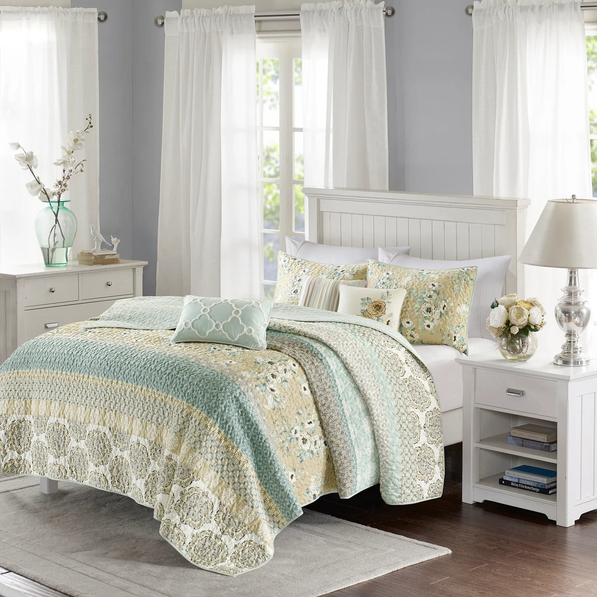 Madison Park King/California King coverlet set with aqua, cream, gold, and gray floral and geometric bands, styled with matching shams and three decorative pillows.