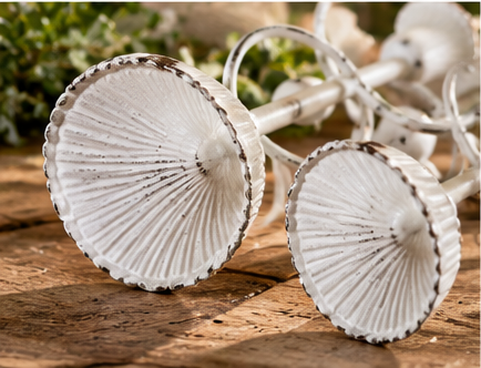 Evelyn metal taper candle holders lying on their sides, showing fluted candle cups and scalloped rims