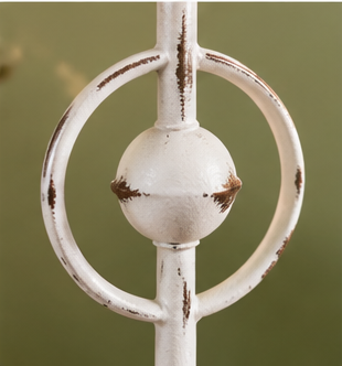 Close-up of the Evelyn candle holder’s circular metal accent and central sphere with distressed white paint