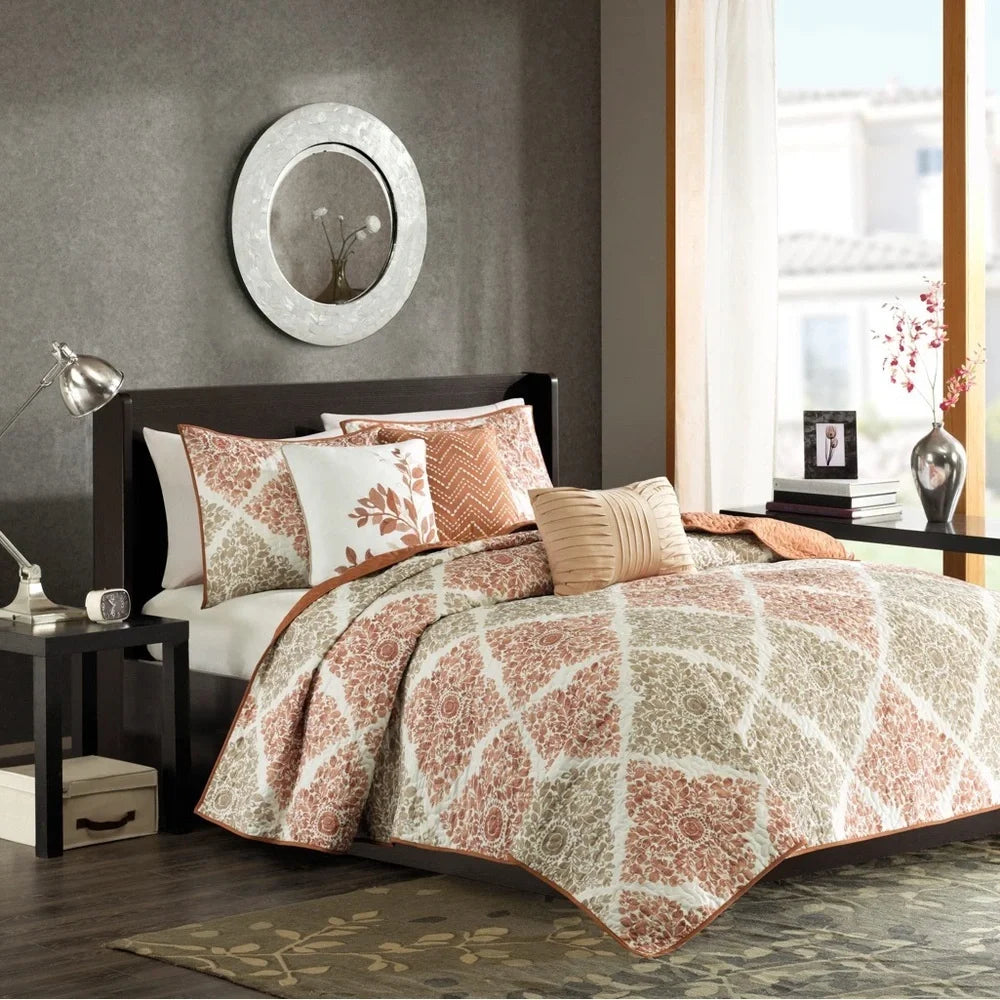 Madison Park Claire six-piece Spice coverlet set with floral medallion patterns, coordinating shams, and three decorative pillows.