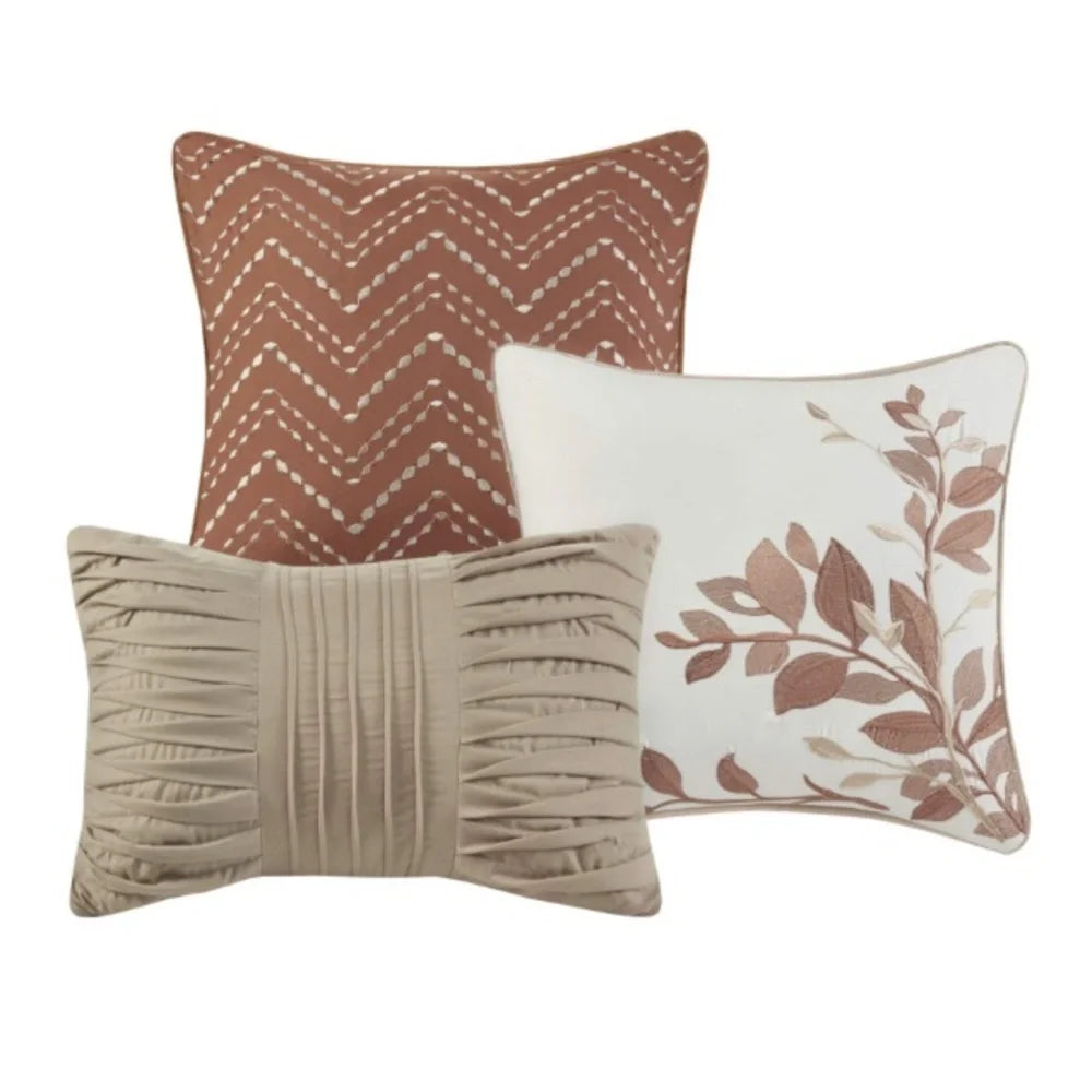 Three Madison Park Claire decorative pillows featuring spice chevron, embroidered leaves, and beige pleated designs.
