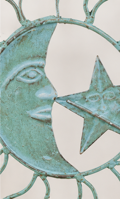 Close-up of the crescent moon face and central star on a teal patina metal wind chime.