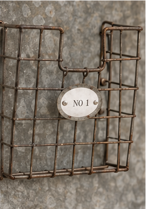 Upper wire storage basket with decorative No 1 label on rustic metal wall caddy